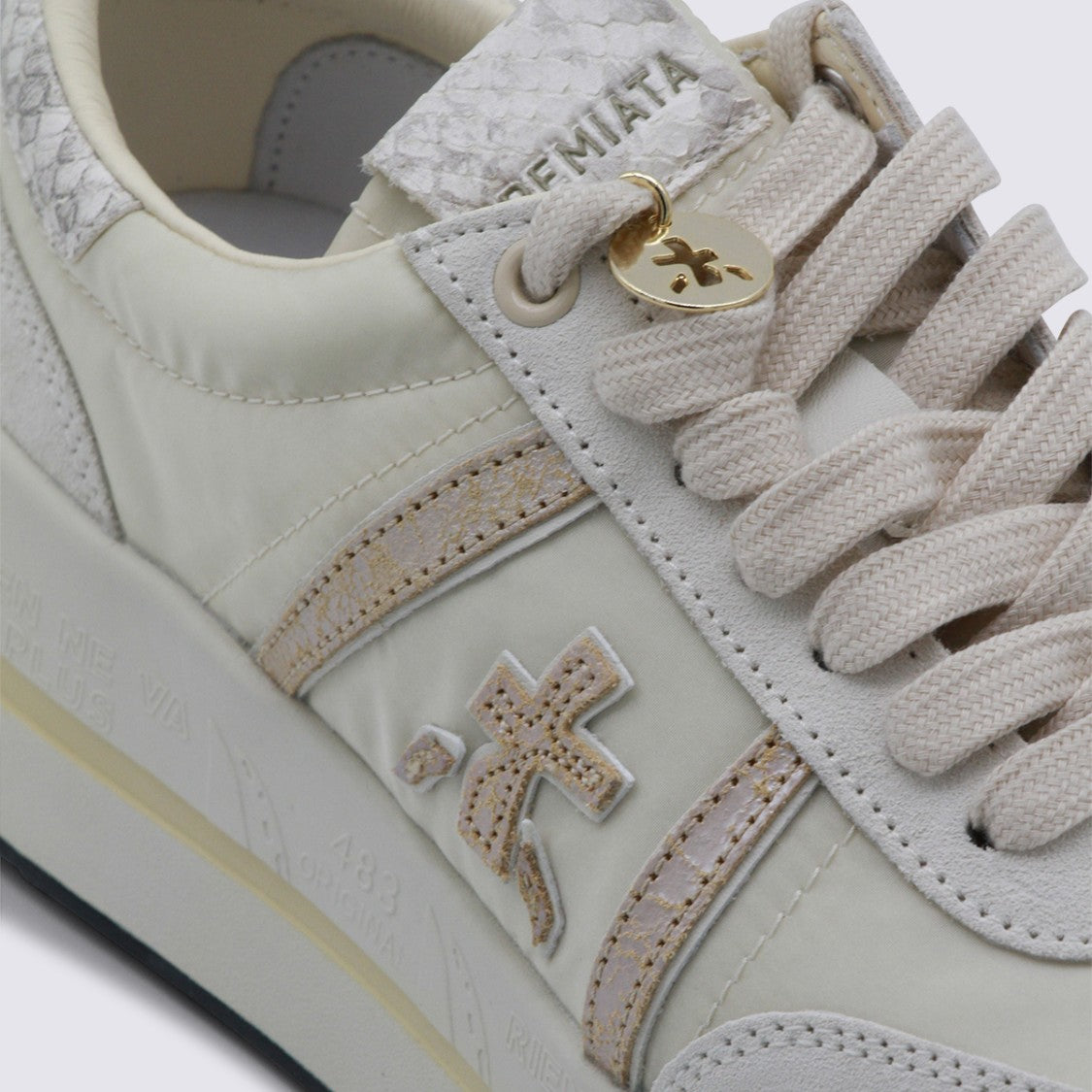Premiata Off-White Sneakers With Textured Accents And Metallic Charm